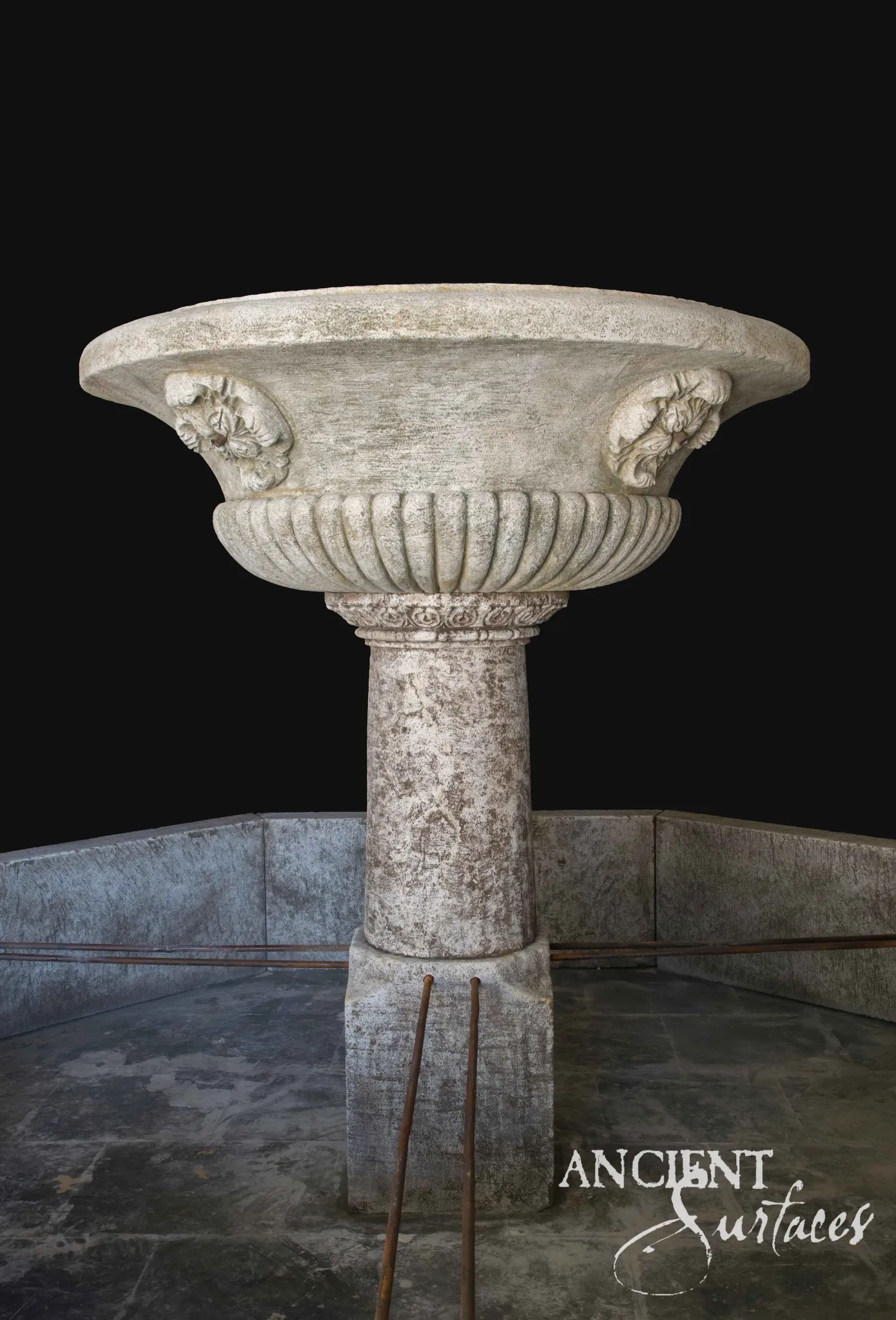 Reclaimed limestone tazza pool fountain with a gadrooned bowl and carved foliate bosses raised on a cylindrical column inside a lined stone pool