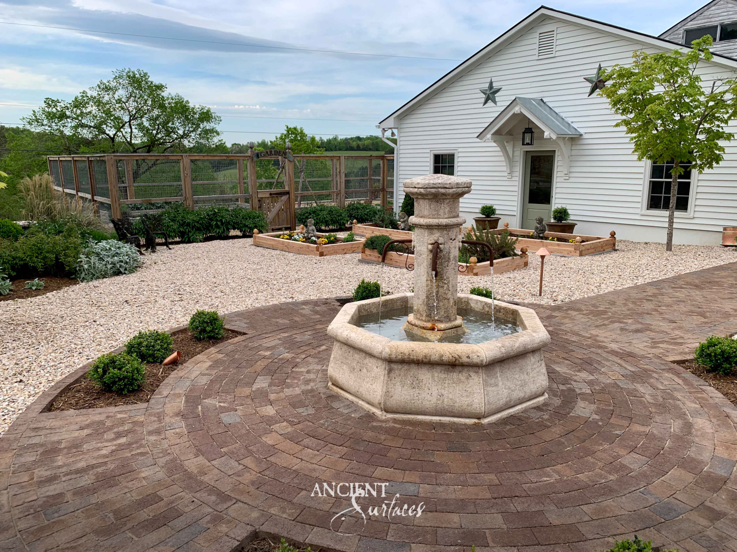 Reclaimed limestone pool fountain running, with iron spouts in a round central pillar sending water across an octagonal limestone pool